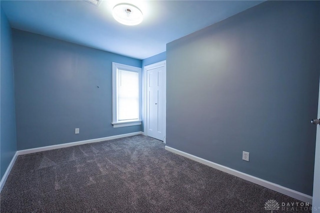 3409 E 5th St, Dayton, OH 45403 - spare room with baseboards and dark colored carpet