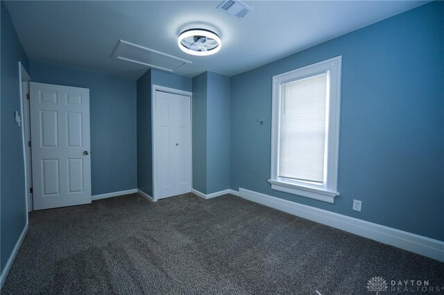 3409 E 5th St, Dayton, OH 45403 - unfurnished bedroom featuring dark carpet, baseboards, and a closet