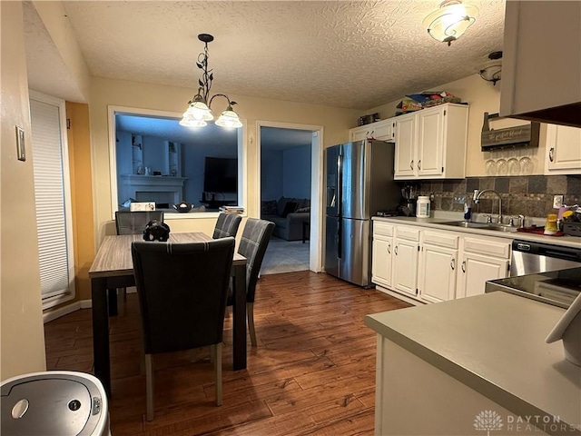 1529 Creekside Rd, Amelia, OH 45102 - kitchen with a sink, appliances with stainless steel finishes, white cabinetry, dark wood-style floors, and pendant lighting