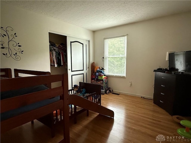 1529 Creekside Rd, Amelia, OH 45102 - bedroom with wood finished floors, a textured ceiling, baseboards, and a closet
