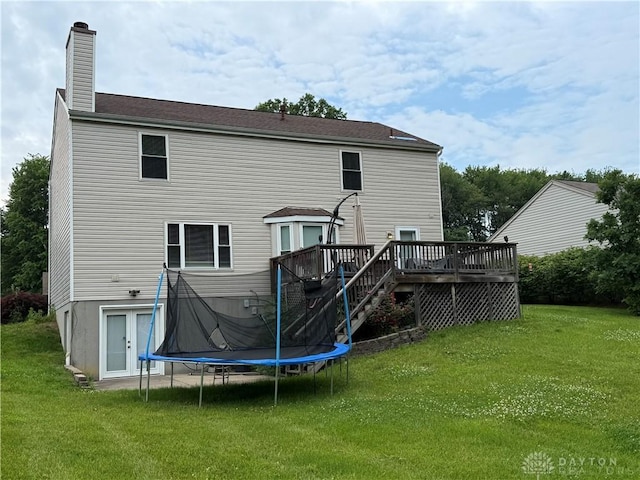 1529 Creekside Rd, Amelia, OH 45102 - rear view of property with a chimney, a wooden deck, a lawn, and a trampoline