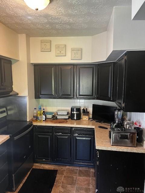 2218 Rugby Rd, Dayton, OH 45406 - kitchen featuring electric range, dark cabinets, light countertops, decorative backsplash, and a textured ceiling