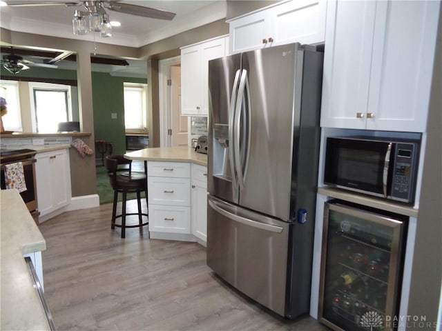 4502 Central Ave, Middletown, OH 45044 - kitchen featuring stainless steel appliances, beverage cooler, ornamental molding, white cabinetry, and ceiling fan