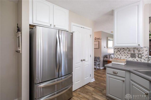 1199 Whitetail Dr, Fairborn, OH 45324 - kitchen featuring freestanding refrigerator, dark wood-style floors, decorative backsplash, white cabinets, and a textured ceiling