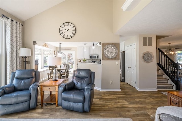 1199 Whitetail Dr, Fairborn, OH 45324 - living room with stairway, wood finished floors, baseboards, high vaulted ceiling, and a chandelier