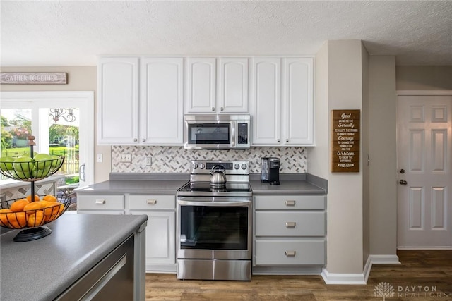 1199 Whitetail Dr, Fairborn, OH 45324 - kitchen featuring stainless steel appliances, dark countertops, white cabinets, and a textured ceiling
