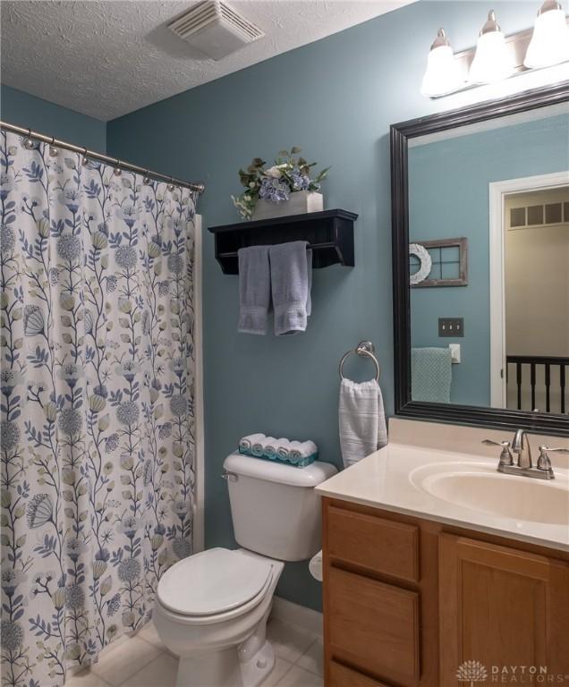 1199 Whitetail Dr, Fairborn, OH 45324 - bathroom with toilet, tile patterned flooring, vanity, a textured ceiling, and a shower with shower curtain