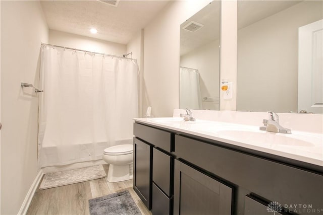 95 Whitney Way, West Milton, OH 45383 - bathroom featuring toilet, double vanity, wood finished floors, shower / bath combo with shower curtain, and baseboards