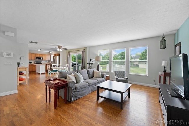 1750 Greentree Meadows Dr, Lebanon, OH 45036 - living room featuring wood finished floors, baseboards, ceiling fan, and a textured ceiling