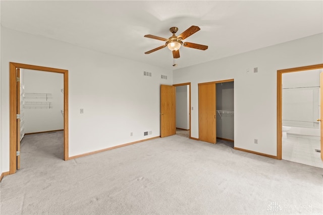 1410 Hunter Ct, Troy, OH 45373 - unfurnished bedroom with a closet, light carpet, connected bathroom, a ceiling fan, and a spacious closet