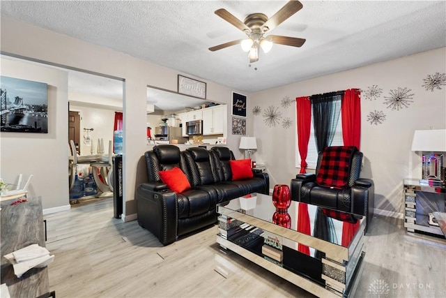 849 Princeton Ave, Fairborn, OH 45324 - living room with light wood-type flooring, ceiling fan, baseboards, and a textured ceiling