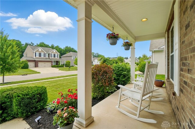 1596 Amberley Ct, Beavercreek Twp, OH 45385 - porch with a residential view, an attached garage, and a yard