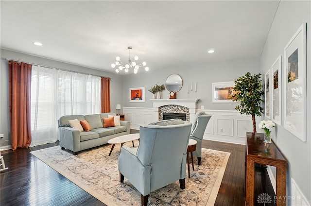 1596 Amberley Ct, Beavercreek Twp, OH 45385 - living room with dark wood-type flooring, a chandelier, a tile fireplace, recessed lighting, and a wainscoted wall