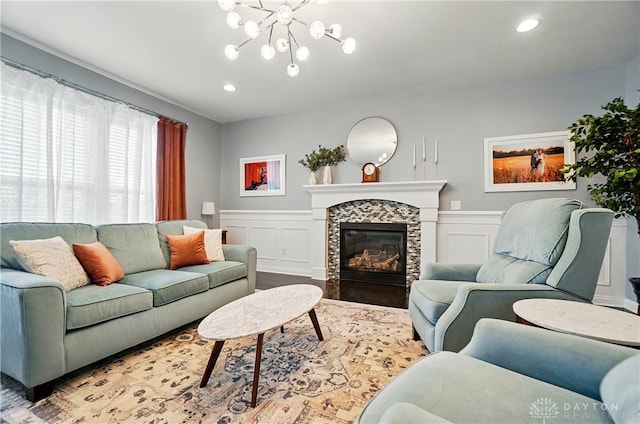 1596 Amberley Ct, Beavercreek Twp, OH 45385 - living area featuring a chandelier, a decorative wall, a tiled fireplace, a wainscoted wall, and recessed lighting