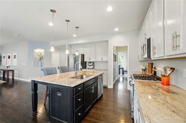 1596 Amberley Ct, Beavercreek Twp, OH 45385 - kitchen featuring appliances with stainless steel finishes, a sink, dark cabinets, a breakfast bar, and white cabinetry