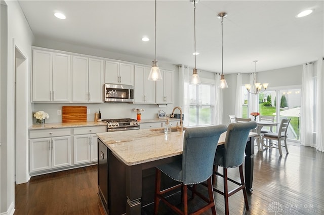 1596 Amberley Ct, Beavercreek Twp, OH 45385 - kitchen featuring stainless steel appliances, white cabinetry, light stone countertops, dark wood finished floors, and a kitchen breakfast bar