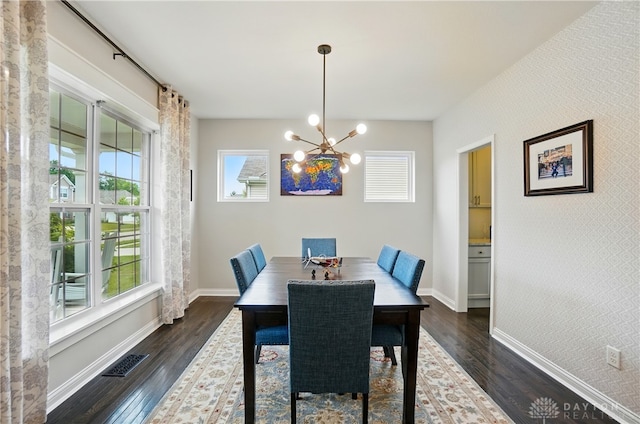 1596 Amberley Ct, Beavercreek Twp, OH 45385 - dining area featuring dark wood-style floors, a chandelier, baseboards, and an accent wall