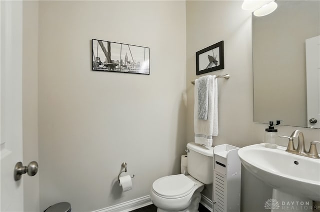 1596 Amberley Ct, Beavercreek Twp, OH 45385 - half bath featuring toilet, a sink, and baseboards