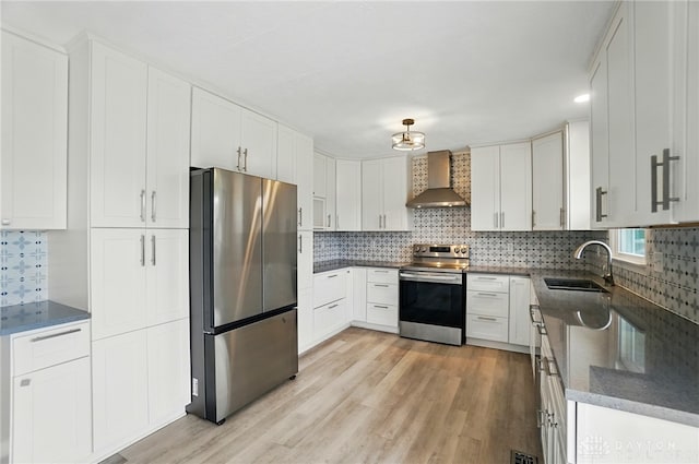 3682 Abbey Ln, Mechanicsburg, OH 43044 - kitchen featuring stainless steel appliances, wall chimney exhaust hood, a sink, decorative backsplash, and light wood-style flooring