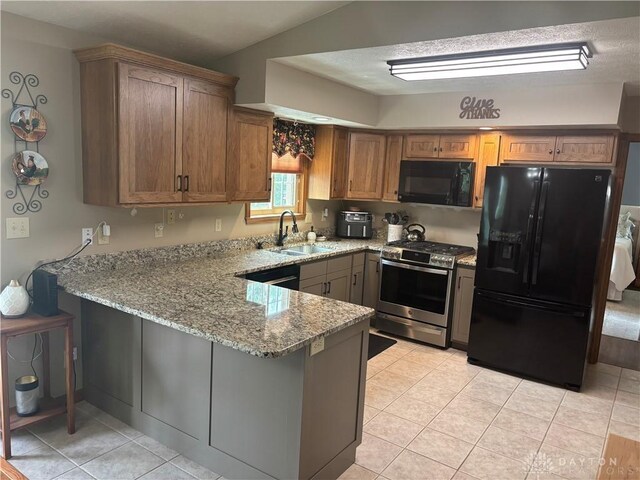 95 Fox Harbor Dr, Troy, OH 45373 - kitchen featuring black appliances, a sink, a peninsula, light stone counters, and light tile patterned floors