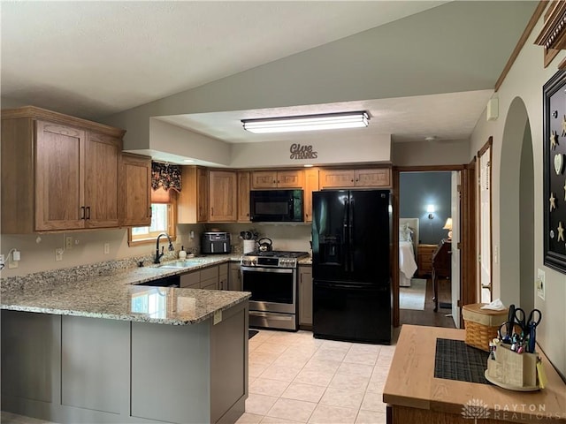 95 Fox Harbor Dr, Troy, OH 45373 - kitchen with black appliances, a sink, arched walkways, a peninsula, and light stone counters