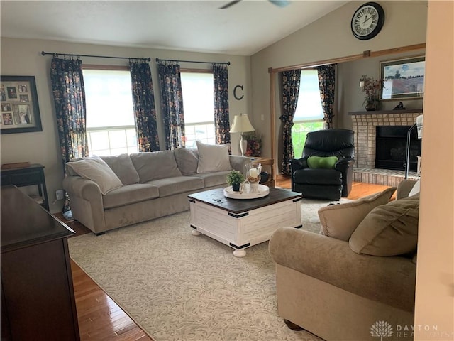 95 Fox Harbor Dr, Troy, OH 45373 - living area featuring wood finished floors, plenty of natural light, lofted ceiling, and a brick fireplace