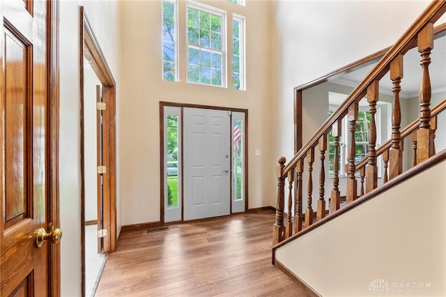 2159 Bassett Ct, Beavercreek, OH 45434 - entryway featuring healthy amount of natural light, light wood finished floors, a towering ceiling, stairway, and baseboards