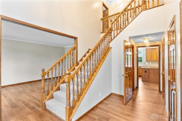 2159 Bassett Ct, Beavercreek, OH 45434 - staircase featuring wood finished floors, crown molding, and baseboards