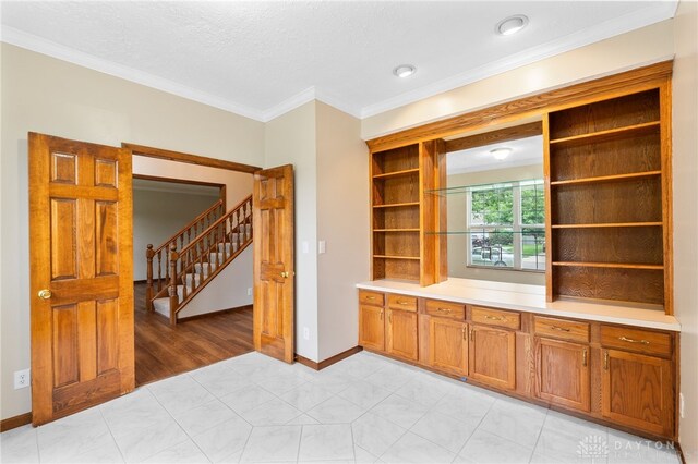 2159 Bassett Ct, Beavercreek, OH 45434 - bar area with ornamental molding, stairs, baseboards, and a textured ceiling