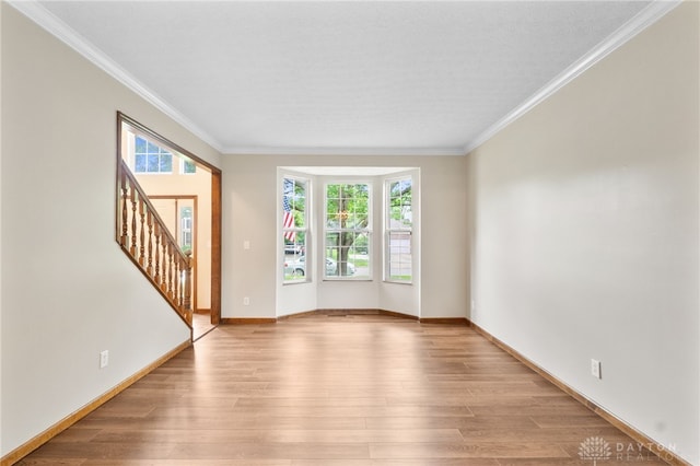 2159 Bassett Ct, Beavercreek, OH 45434 - empty room with crown molding, stairs, light wood finished floors, and baseboards