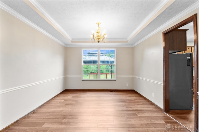 2159 Bassett Ct, Beavercreek, OH 45434 - empty room featuring a chandelier, light wood-style flooring, a raised ceiling, ornamental molding, and a textured ceiling