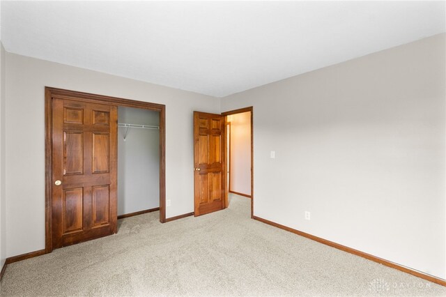 2159 Bassett Ct, Beavercreek, OH 45434 - unfurnished bedroom with baseboards, light carpet, and a closet