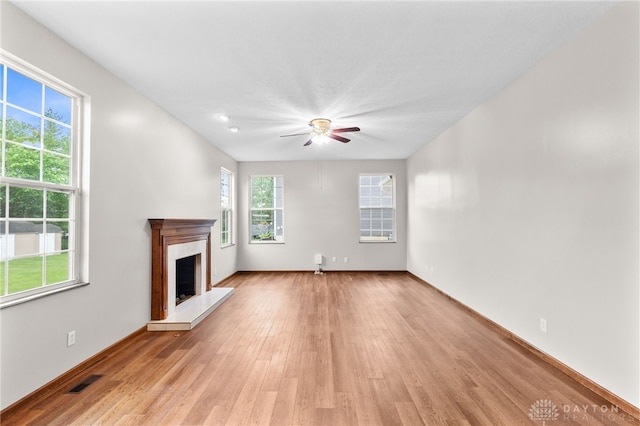 2159 Bassett Ct, Beavercreek, OH 45434 - unfurnished living room featuring light wood finished floors, a ceiling fan, a fireplace, and baseboards