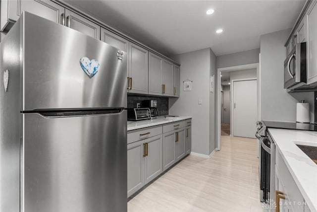 2230 S Patterson Blvd Unit 21, Dayton, OH 45409 - kitchen with stainless steel appliances, gray cabinetry, recessed lighting, tasteful backsplash, and light wood-style flooring