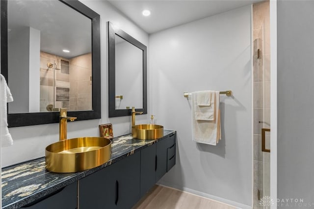 2230 S Patterson Blvd Unit 21, Dayton, OH 45409 - full bathroom with double vanity, a tile shower, wood finished floors, and recessed lighting