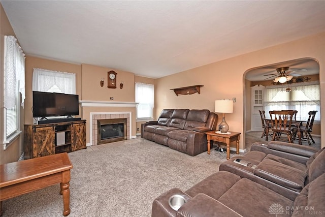1064 Wilmington Ave, Dayton, OH 45420 - living area with carpet flooring, a ceiling fan, a tiled fireplace, and arched walkways