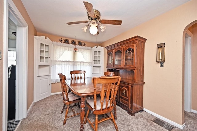 1064 Wilmington Ave, Dayton, OH 45420 - dining room featuring arched walkways, a ceiling fan, light carpet, and baseboards