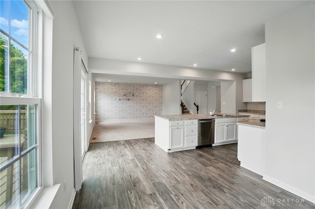 344 Warm Springs Dr, Fairborn, OH 45324 - kitchen with stainless steel dishwasher, a sink, open floor plan, white cabinets, and brick wall