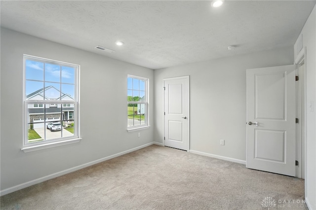 344 Warm Springs Dr, Fairborn, OH 45324 - unfurnished bedroom with multiple windows, baseboards, light carpet, recessed lighting, and a textured ceiling