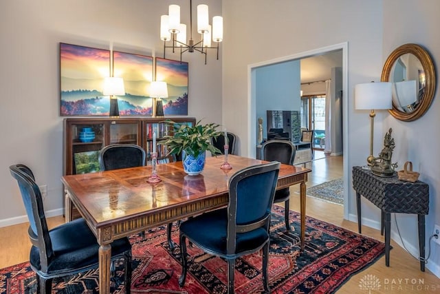 1126 Justin Ridge Way, Waynesville, OH 45068 - dining room featuring a chandelier, wood finished floors, and baseboards