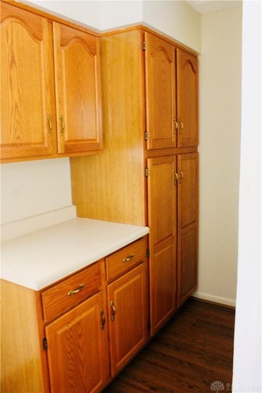 2589 Midvale St, Dayton, OH 45420 - kitchen with light countertops, dark wood-style floors, baseboards, and brown cabinetry