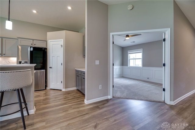 72 Pebble Brook Pl, Springboro, OH 45066 - kitchen featuring light wood-style floors, light countertops, gray cabinets, lofted ceiling, and stainless steel refrigerator with ice dispenser