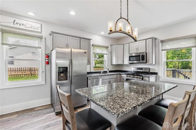 1153 Highridge Ave, Dayton, OH 45420 - kitchen featuring stainless steel appliances, gray cabinetry, a breakfast bar, dark stone countertops, and recessed lighting