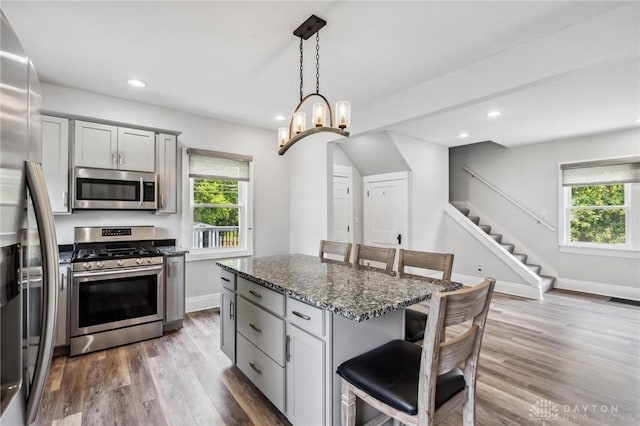 1153 Highridge Ave, Dayton, OH 45420 - kitchen featuring stainless steel appliances, a breakfast bar area, dark stone counters, wood finished floors, and recessed lighting