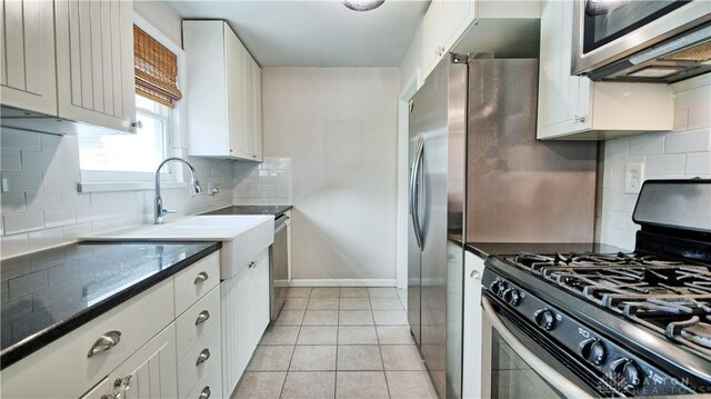 344 Triangle Ave, Oakwood, OH 45419 - kitchen with appliances with stainless steel finishes, decorative backsplash, white cabinetry, light tile patterned flooring, and baseboards