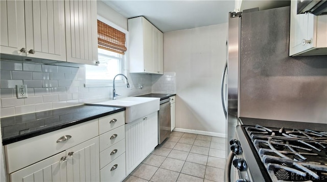 344 Triangle Ave, Oakwood, OH 45419 - kitchen with dark countertops, light tile patterned floors, decorative backsplash, white cabinets, and stainless steel gas stove