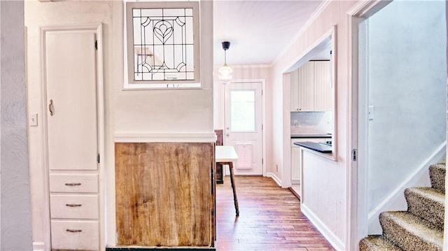 344 Triangle Ave, Oakwood, OH 45419 - kitchen featuring wood finished floors, crown molding, white cabinets, and backsplash