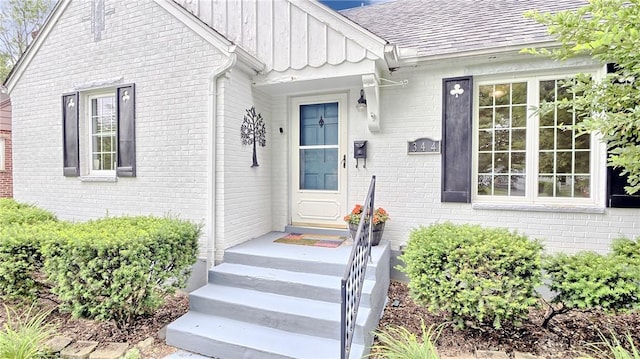 344 Triangle Ave, Oakwood, OH 45419 - view of exterior entry with board and batten siding, brick siding, and roof with shingles
