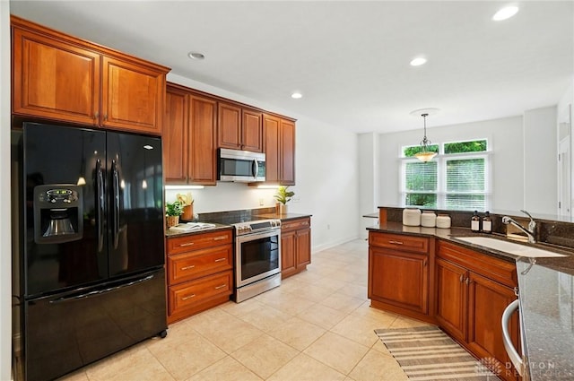 160 Harbour Dr, Springboro, OH 45066 - kitchen featuring stainless steel appliances, a sink, dark stone counters, brown cabinetry, and decorative light fixtures