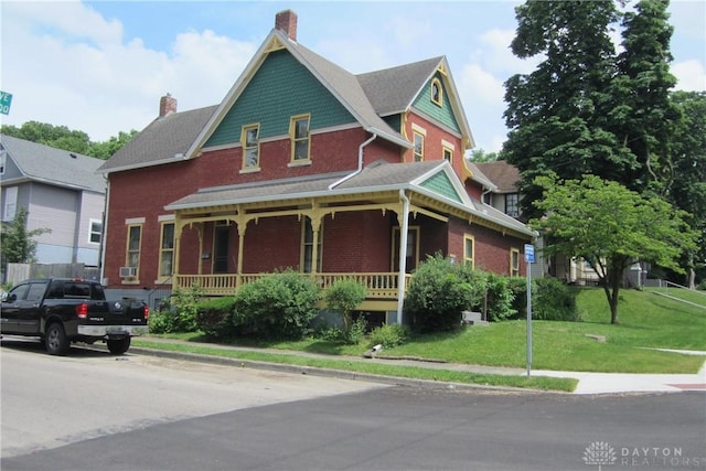 1600 Wayne Ave, Dayton, OH 45410 - victorian house featuring a porch, a chimney, a front yard, and brick siding